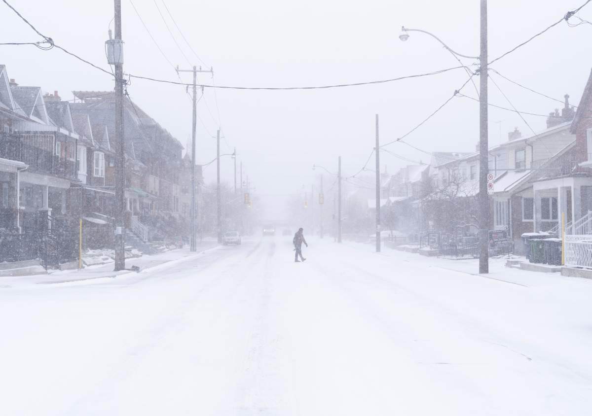 A man crosses a road during a snowstorm in Toronto on Friday, December, 23, 2022.