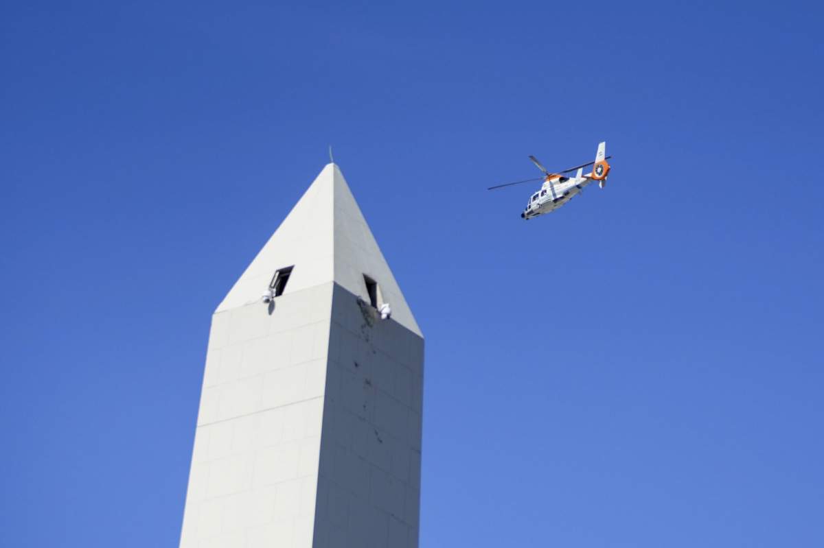 A helicopter flies over the Obelisk where people gathered in hopes of seeing the Argentine national soccer team that won the World Cup title in Buenos Aires, Argentina, Tuesday, Dec. 20, 2022. So many people swarmed highways surrounding the capital that the players ended up having to abandon the bus and get on helicopters, and what was set to become a parade through the streets became an aerial parade. (AP Photo/Matilde Campodonico)