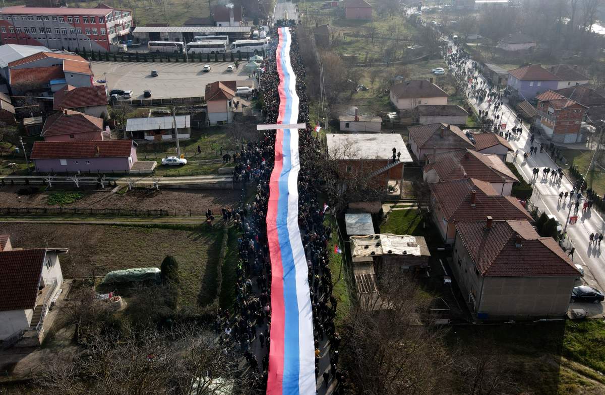 Kosovo Serbs carry a giant Serbian flag during a protest near a barricade on the road near the village of Rudare, north of Serb-dominated part of ethnically divided town of Mitrovica, Kosovo, Thursday, Dec. 22, 2022. The European Union rule of law mission, known as EULEX, on Tuesday considered as “concerning and tense” and “unacceptable” the increasing alarming situation in northern Kosovo where Serbs have erected barricades on the main roads in an anew flaring of the bilateral tensions.