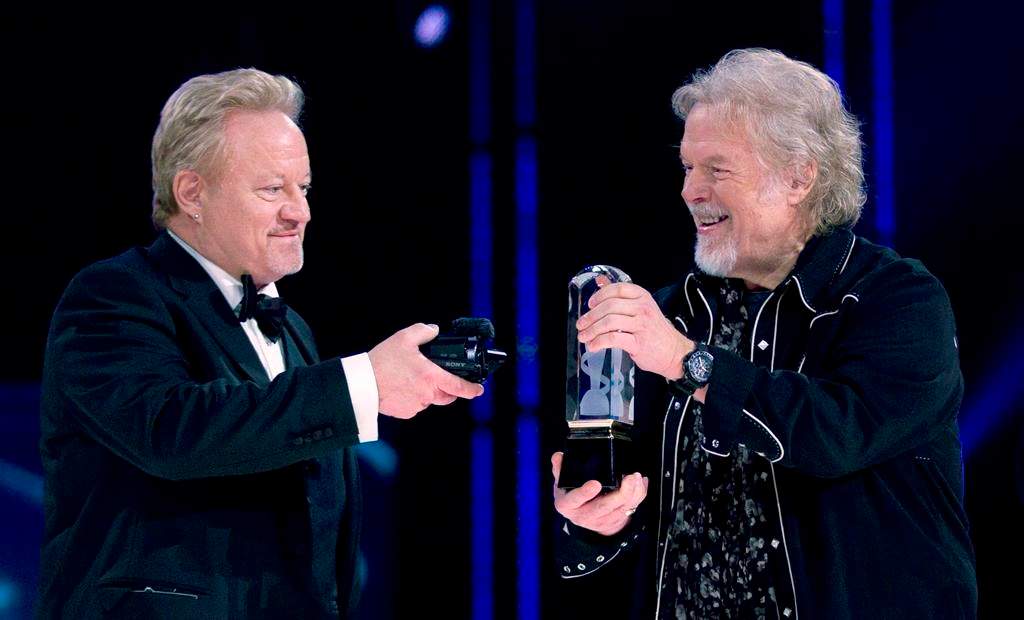 Randy Bachman (right) holds the Juno as Robbie Bachman videotapes a closeup of the trophy after being inducted into the Canadian Music Hall of Fame at the Juno Awards in Winnipeg, Sunday, March 30, 2014.