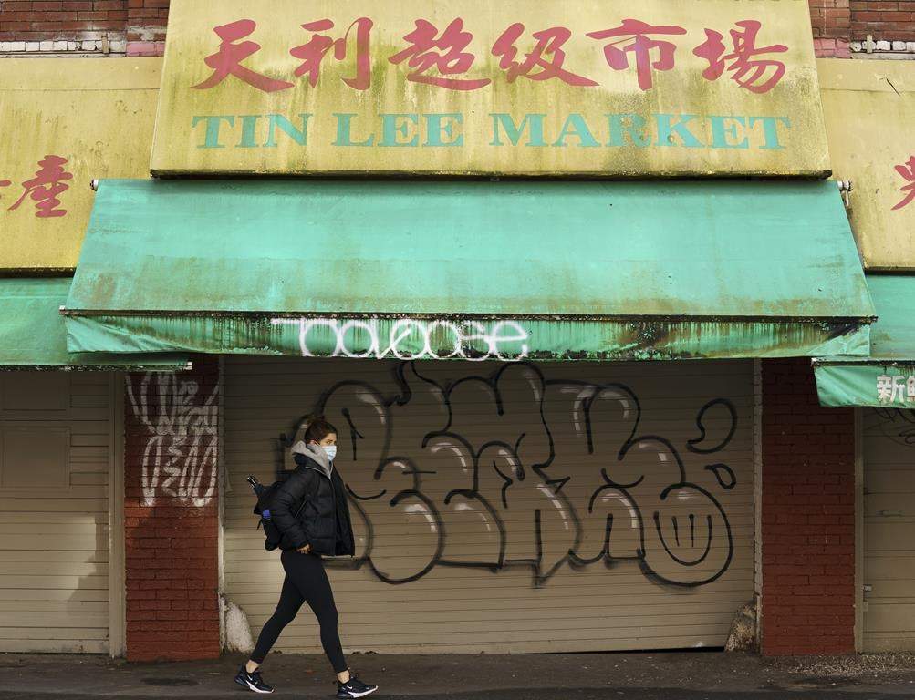 A woman walks in Chinatown in Vancouver, Friday, Feb. 5, 2021.