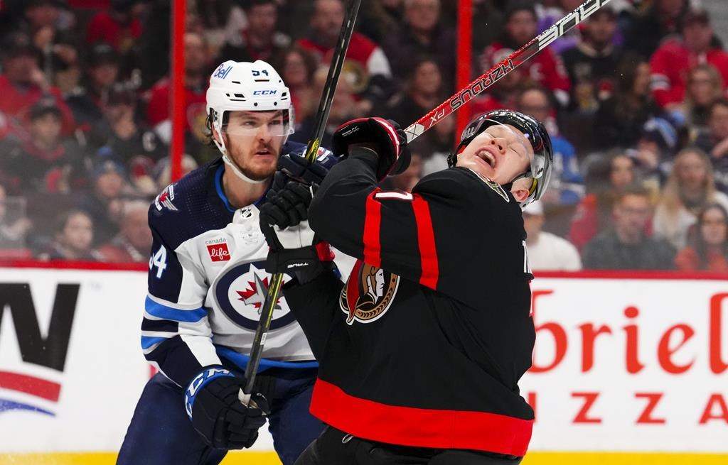 Ottawa Senators left wing Brady Tkachuk (7) reacts to a stick check from Winnipeg Jets defenceman Dylan Samberg (54) during second-period NHL hockey action in Ottawa on Saturday, Jan. 21, 2023.