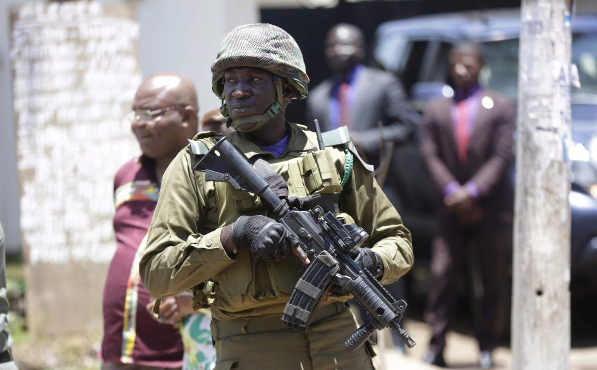 A soldier stands guard outside a polling station where, Cameroon's Incumbent President Paul Biya of the Cameroon People's Democratic Movement party, casts his vote during the Presidential elections in Yaounde, Cameroon, Sunday Oct. 7, 2018. Polls opened Sunday in Cameroon as Africa's oldest leader is widely expected to win another term, while separatists threaten to disrupt the election and many people who have fled the unrest are unable to vote. (AP Photo/Sunday Alamba).