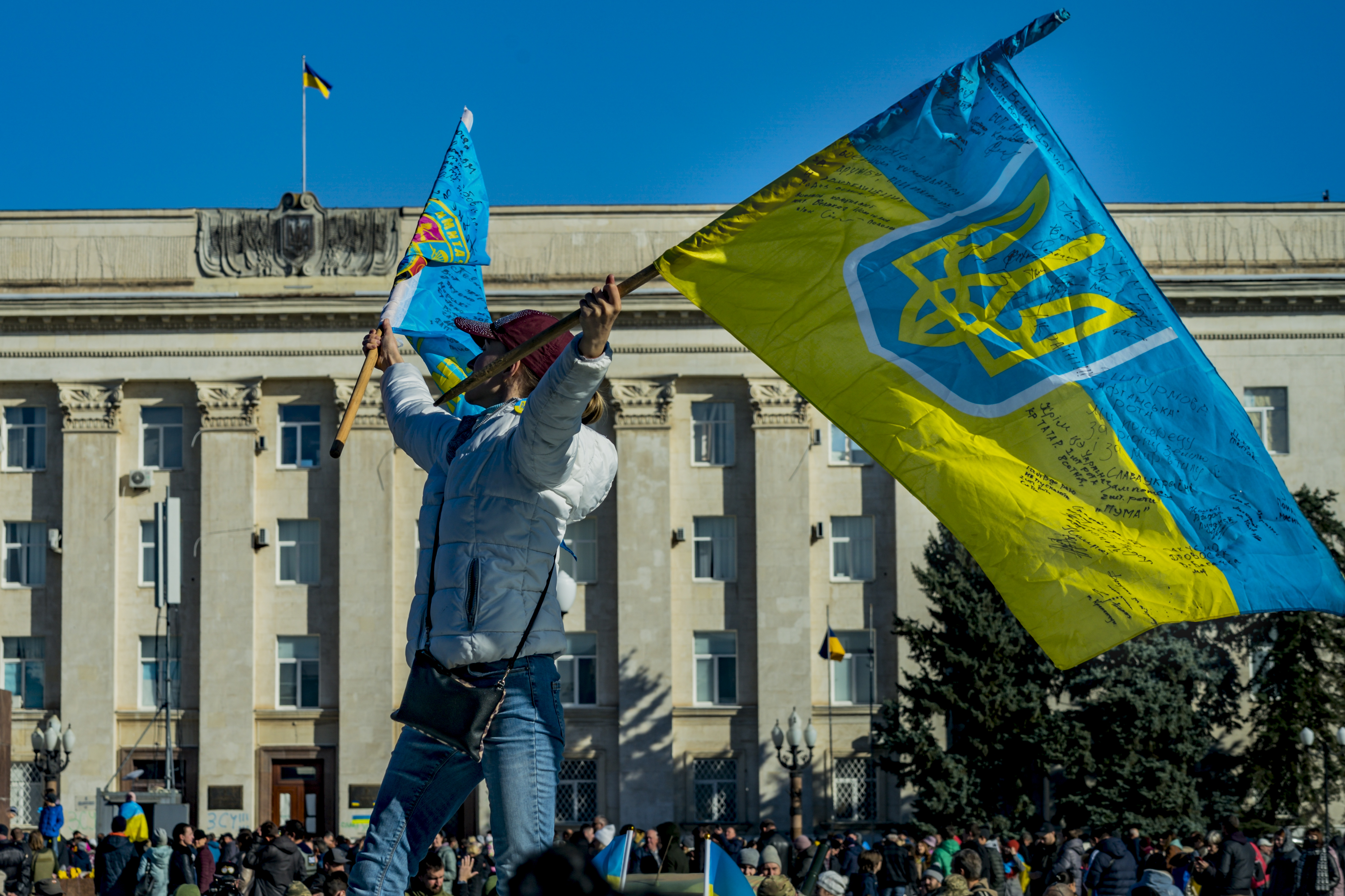 A woman waves a Ukrainian flag following the liberation of Kherson from eight months of Russian occupation, Nov. 14, 2022, Kherson, Ukraine (Celestino Arce Lavin/ZUMA Press Wire)