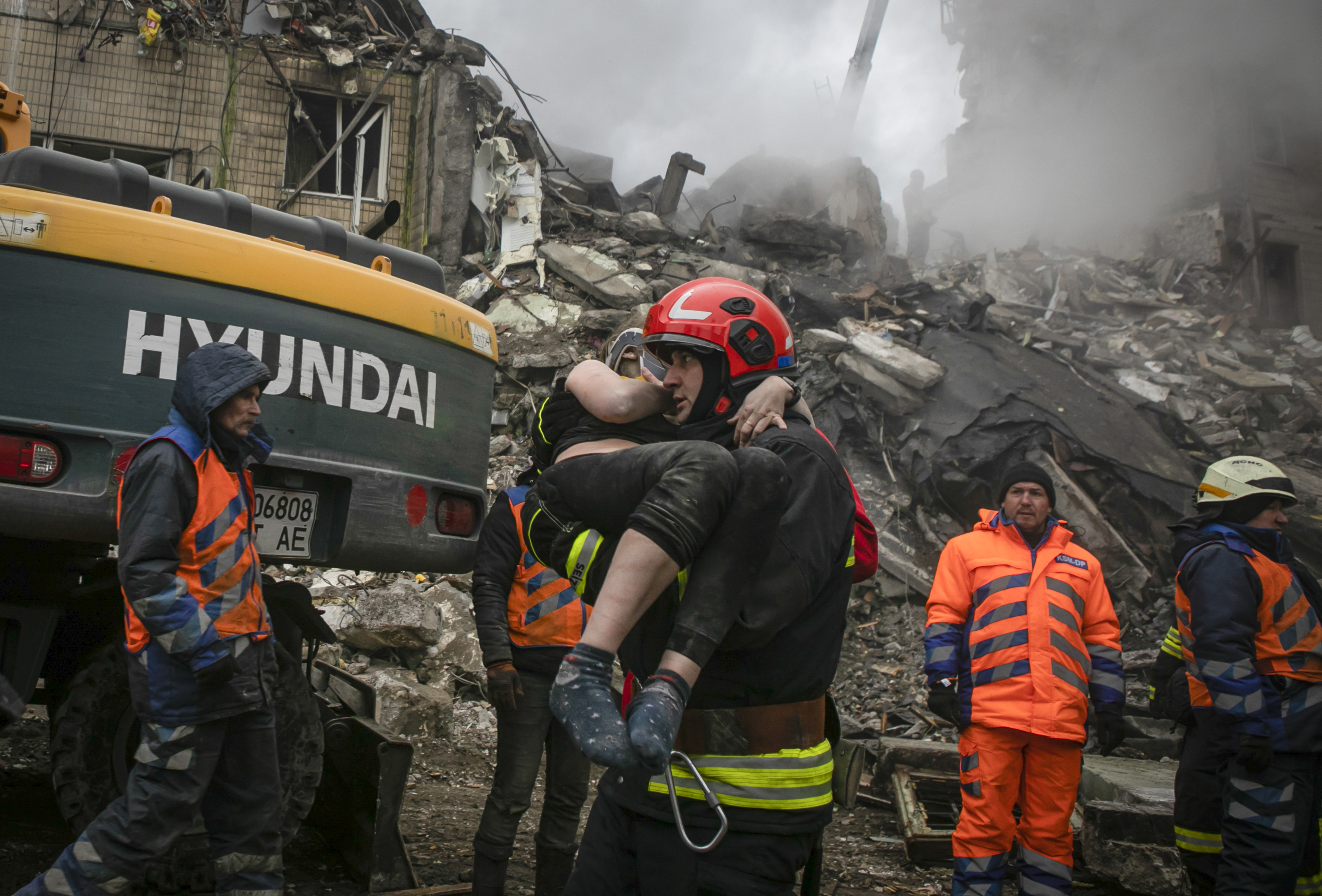 Emergency workers carry a wounded woman after a Russian rocket hit a multi-storey building on Saturday in Dnipro, Ukraine, Sunday, Jan. 15, 2023. (AP Photo/Yevhenii Zavhorodnii)