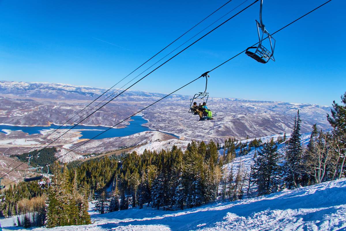 A ski lift. There are mountains and trees in the background.