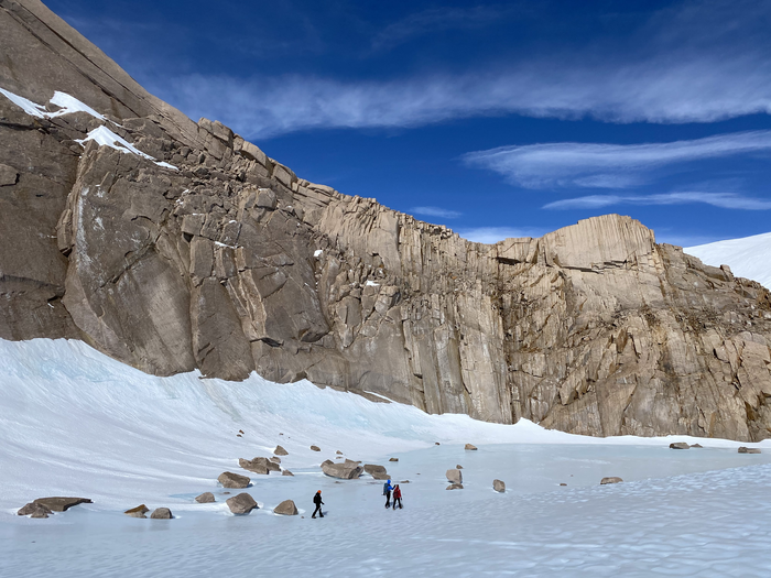 The research team hiking past rock formations in Antarctica.