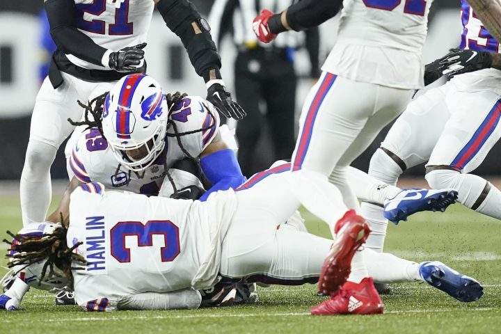 Buffalo Bills safety Damar Hamlin (3) falls to the turf as Buffalo Bills linebacker Tremaine Edmunds (49) helps him during the first half of an NFL football game between the Cincinnati Bengals and the Buffalo Bills, Monday, Jan. 2, 2023, in Cincinnati.