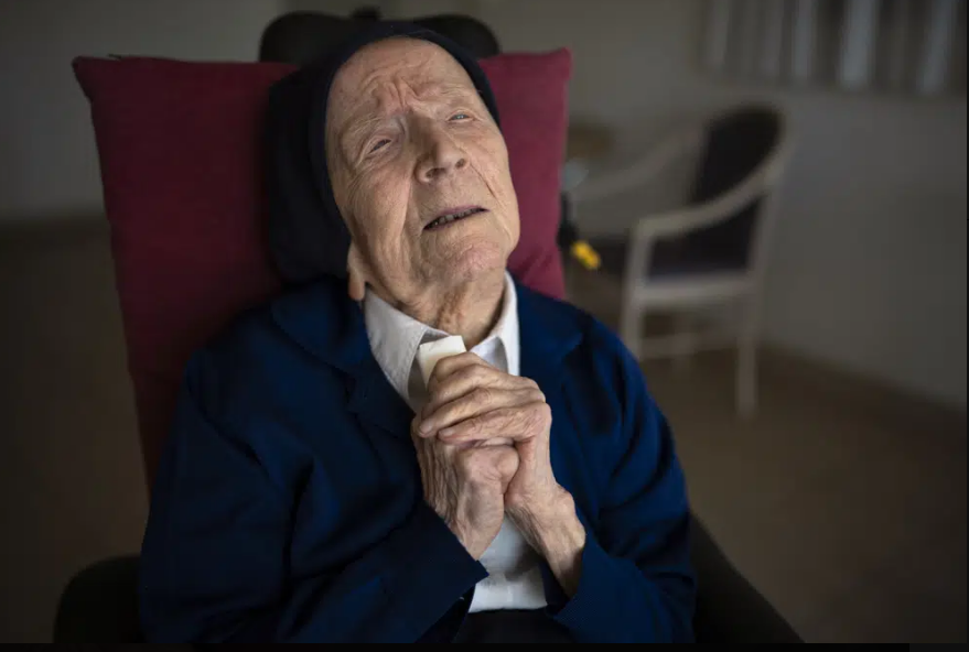 Sister Andre. She is wearing a habit. Her hands are clasped.