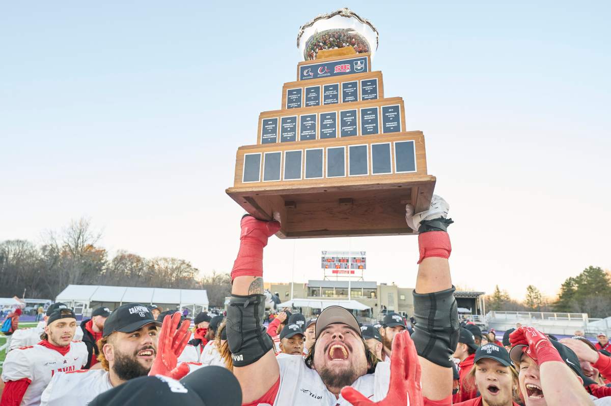 Laval’s Antoine Dean Rios hoist the Vanier Cup following the Rouge et Or’s victory over the Saskatchewan Huskies at Alumni Stadium in London, Ont., Saturday, Nov. 26, 2022. 
