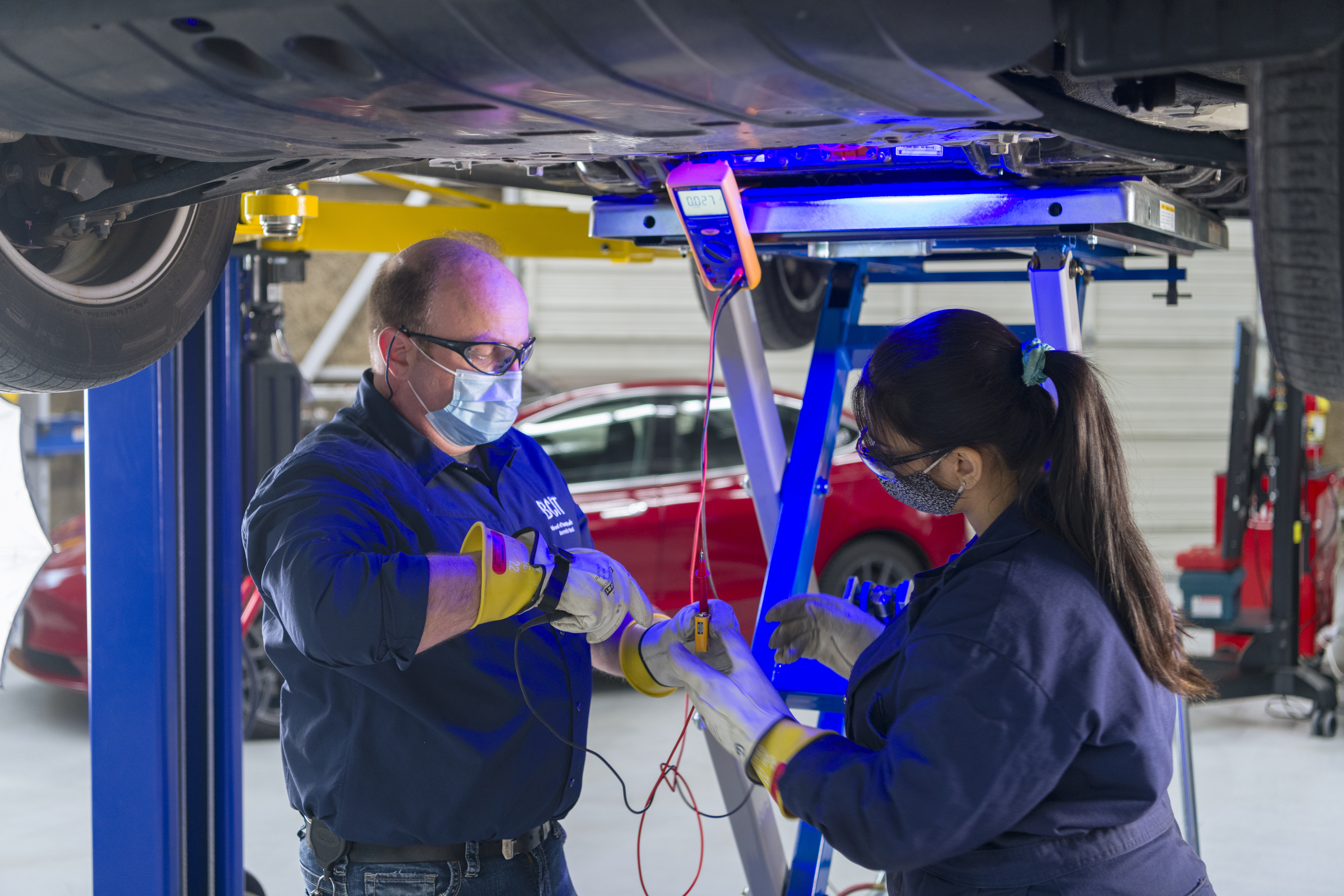 An instructor helps a student conduct what's known as a "live-dead-live" test to confirm there's no voltage coming out of an EV battery. Only then can the battery be safely removed for service or repair.