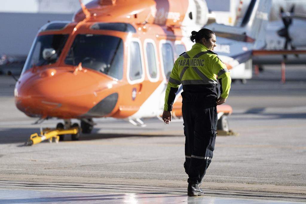 An arbitrator has ruled that air ambulance service Ornge must pay its paramedics more money after wage restraint legislation known as Bill 124 was struck down. A medic walks past an ORNGE air ambulance service helicopter at their base at Billy Bishop Airport in Toronto on Tuesday, December 13, 2022. 