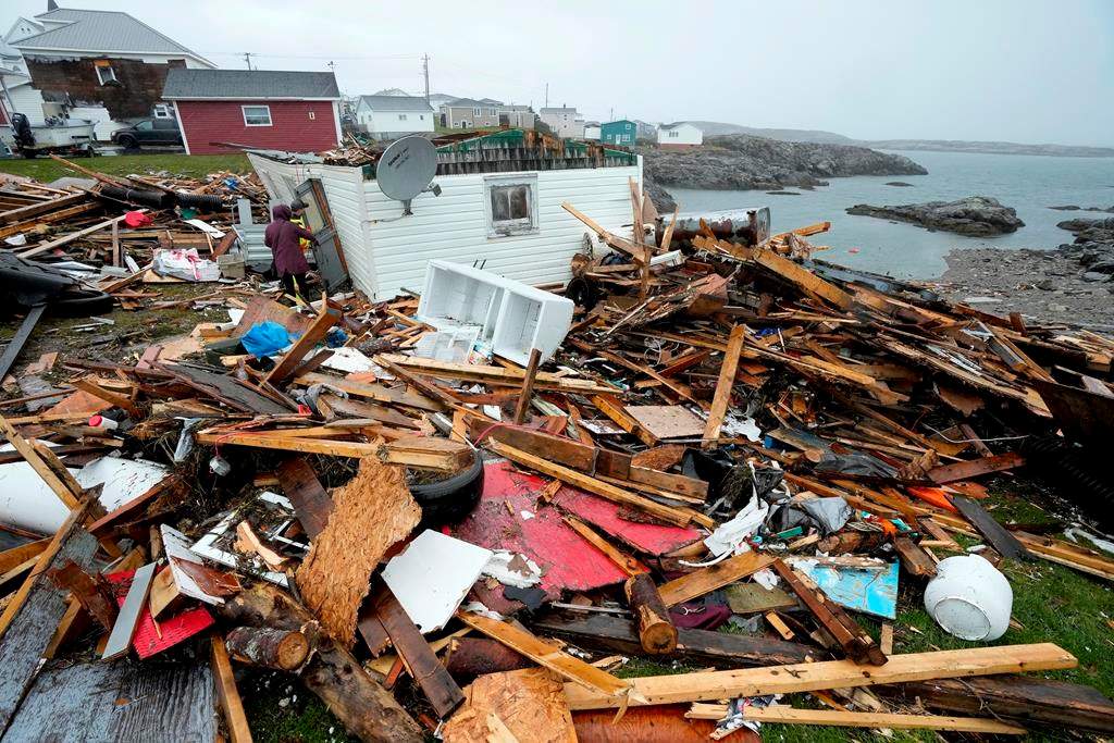 A resident and search and rescue worker examine the destroyed remains of a home in Port aux Basques, N.L., Monday, Sept.26, 2022. THE CANADIAN PRESS/Frank Gunn