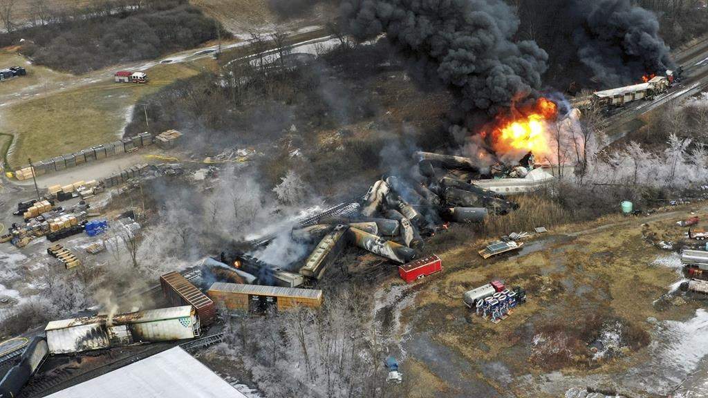 The wreckage from the train derailment. There is fire in the image.