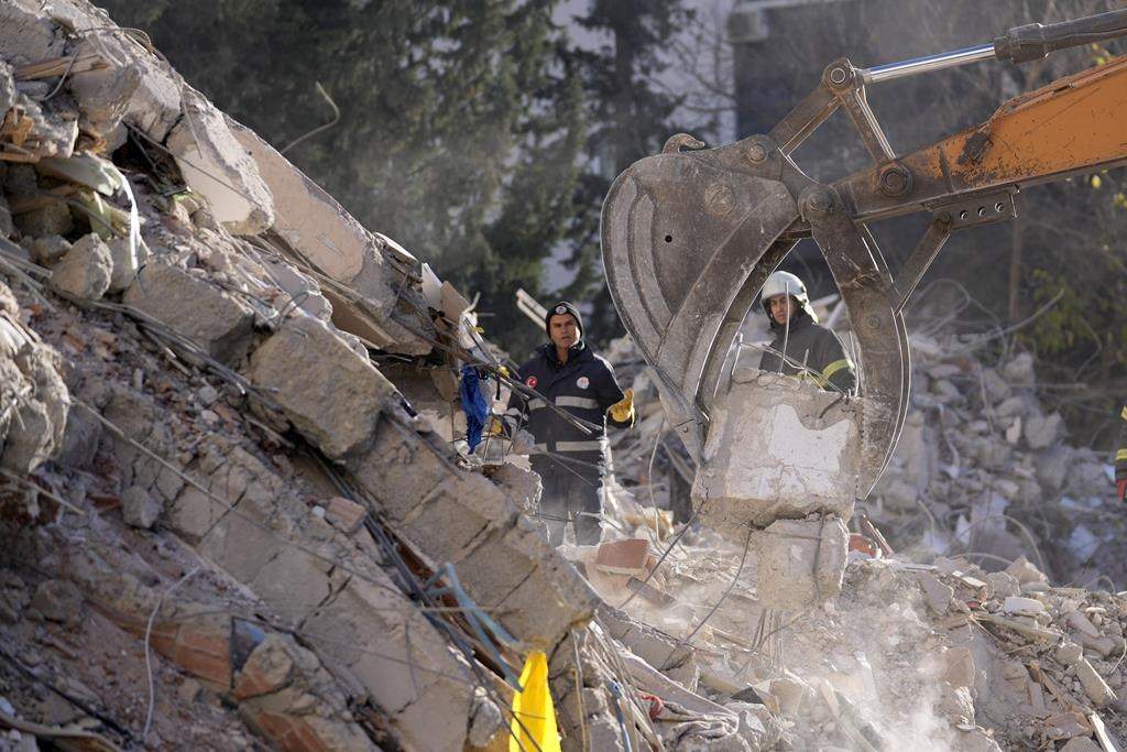 Emergency teams search for people in the rubble of a destroyed building in Adana, southern Turkey, Tuesday, Feb. 7, 2023.