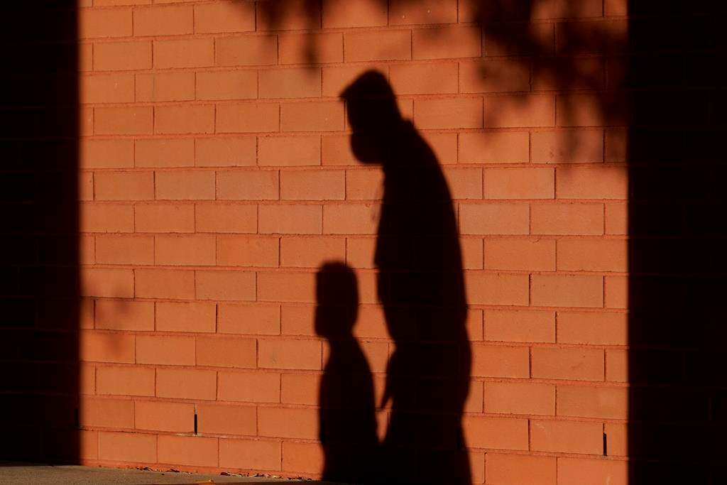 The shadows of a school employee escorting a student are shown at a school in Davie, Fla. on Friday, Oct.9, 2020. Hundreds of Ontario principals say they need more help to support the mental health of students, as a new survey exposes regional inequities in access to those supports.