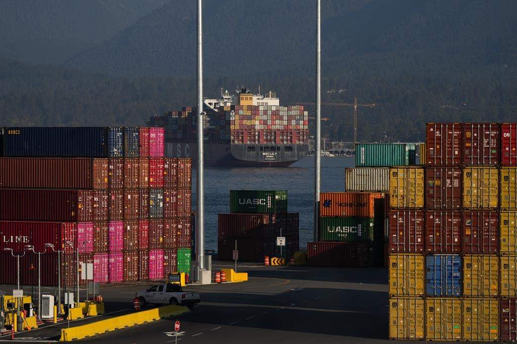 Cargo containers are seen stacked at the Port of Vancouver Centerm container terminal as the container ship MSC Lily sits at anchor in the harbour, in Vancouver, on Friday, Oct. 14, 2022.