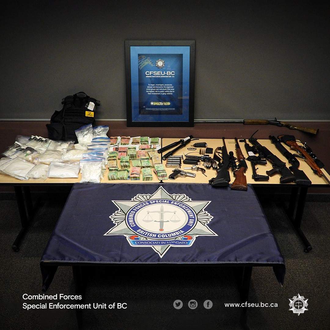 Another photo showing some of the drugs, cash and firearms that were seized.