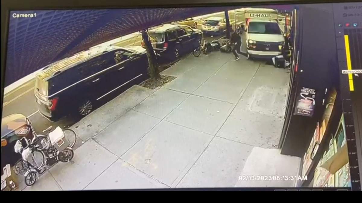 In this photo taken from security video, a man jumps out of the way as a U-Haul truck drives onto the sidewalk, Monday, Feb. 13, 2023, in the Brooklyn borough of New York. Authorities say a man driving a U-Haul truck struck and injured several pedestrians in New York City before police were able to pin the careening vehicle against a building following a mileslong pursuit through Brooklyn. (Jorge Aldaz via AP)