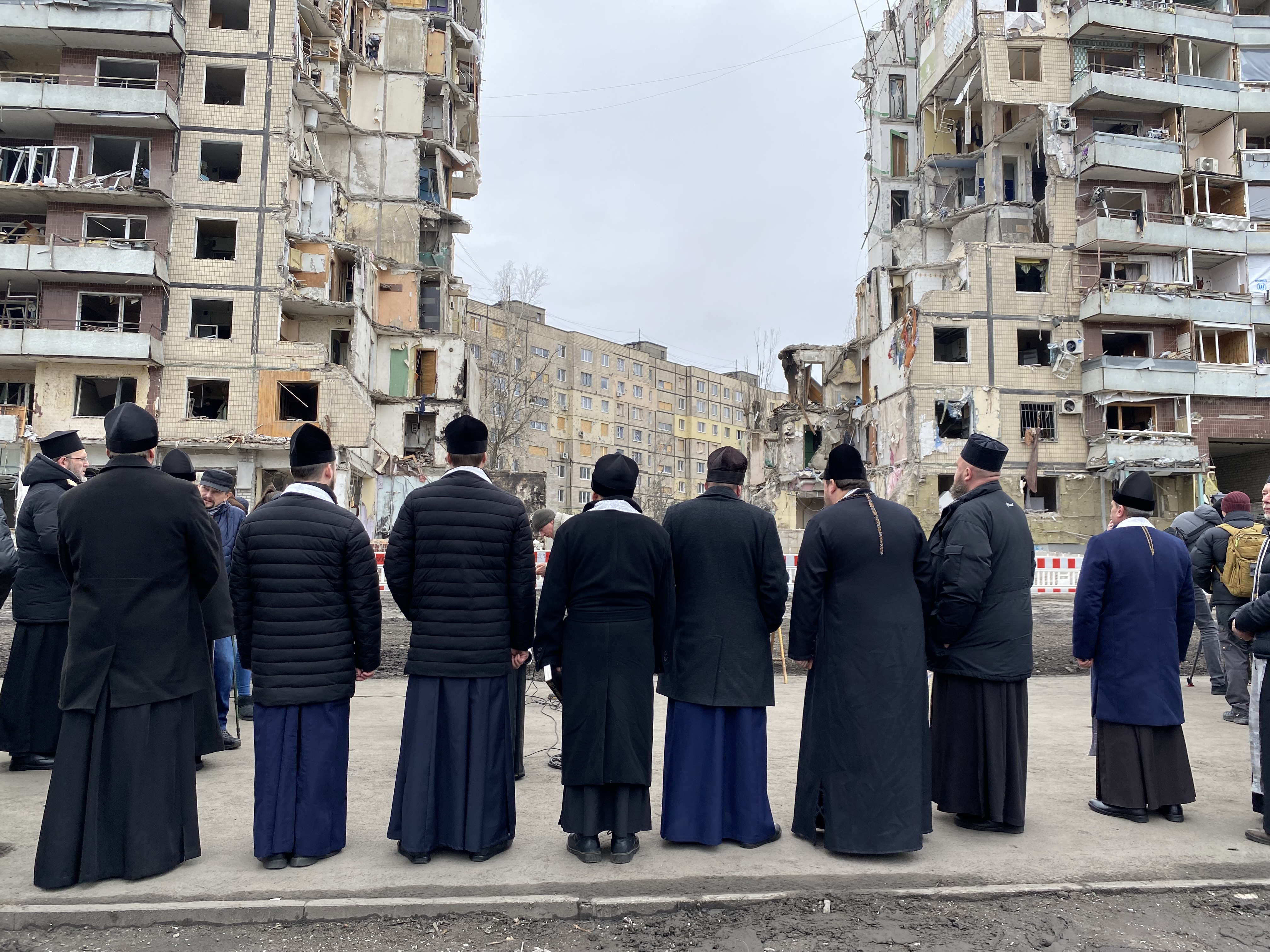 Orthodox priests at the site of a Jan. 14 missile attack on an apartment building in Dnipro, Ukraine.