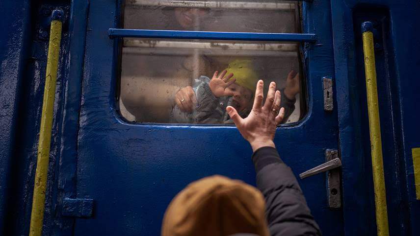 A father says goodbye to his wife and child at Kyiv Central Station.