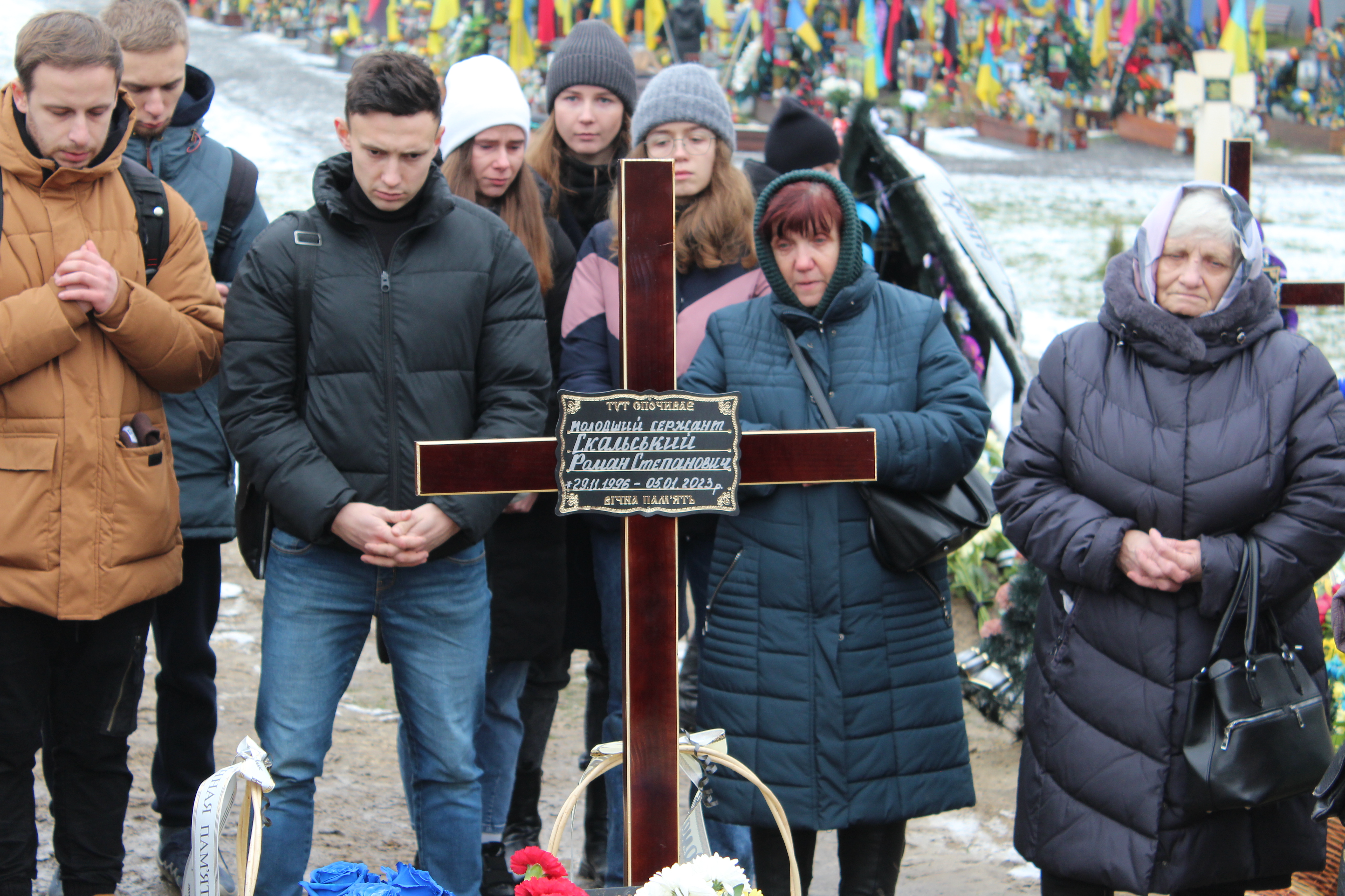 Mourners stand over the grave of Roman Skalskyi, Lviv, Ukraine, Jan. 16, 2023.