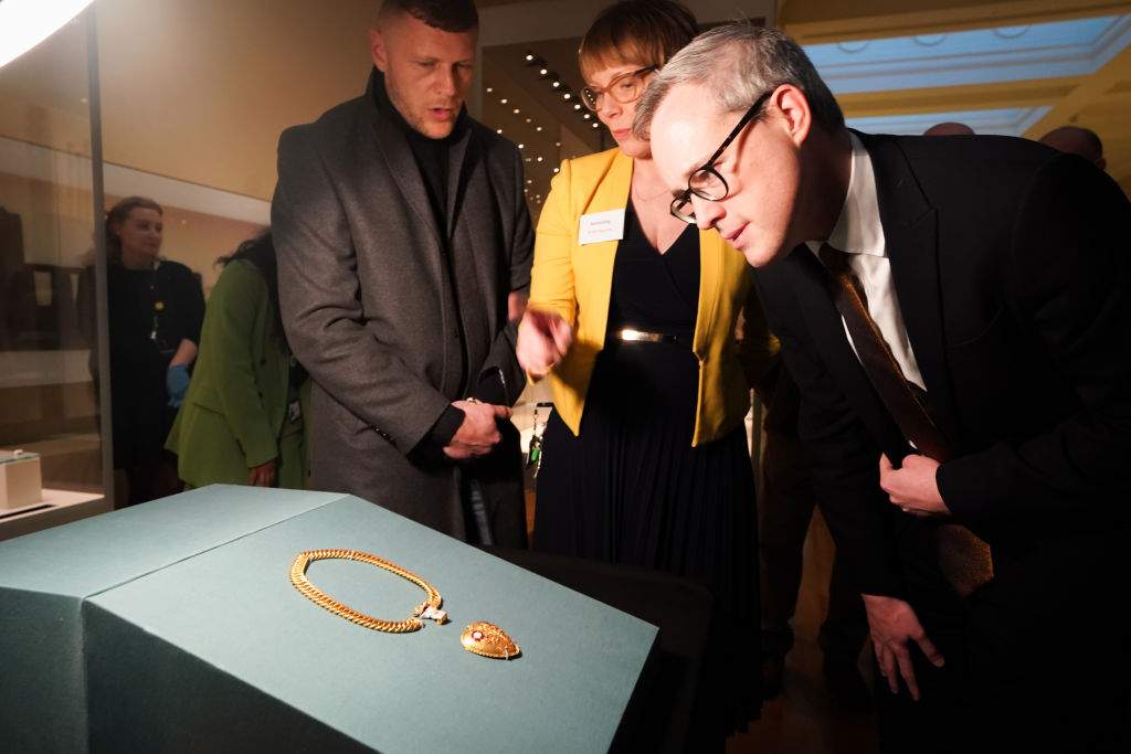 The finder of the chain and pendant associated with Henry VIII and Katherine of Aragon, Charlie Clarke (left) and Arts and Heritage Minister, Lord Parkinson of Whitley Bay (right) look at the pendant on display at the British Museum in London as archaeological discoveries made by members of the public are revealed via the Portable Antiquities Scheme (PAS).