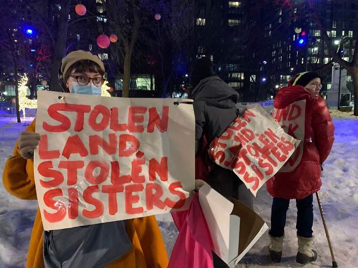 Supporters at a MMIWT2S+ rally in Montreal carry signs that read” Stolen land, stolen sisters.” Tuesday, Feb. 14, 2023.