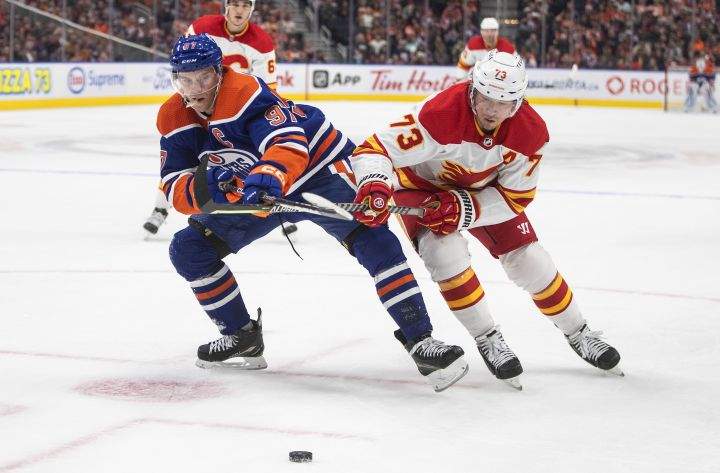Calgary Flames’ Tyler Toffoli (73) and Edmonton Oilers’ Connor McDavid (97) battle for the puck during second period pre-season action in Edmonton on Friday, September 30, 2022.