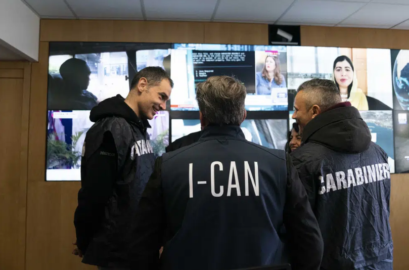 Authorities stand in a surveillance room.