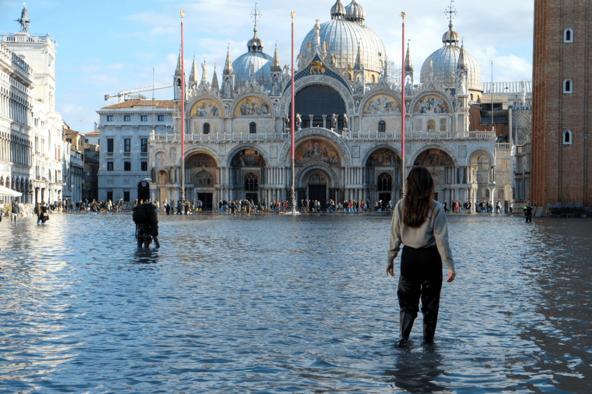 A woman stands in ankle high water.