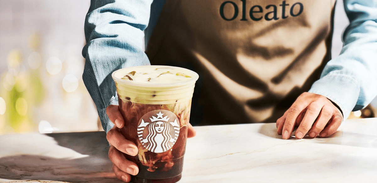 A Starbucks coffee. The barista is wearing an 'Oleato' apron.