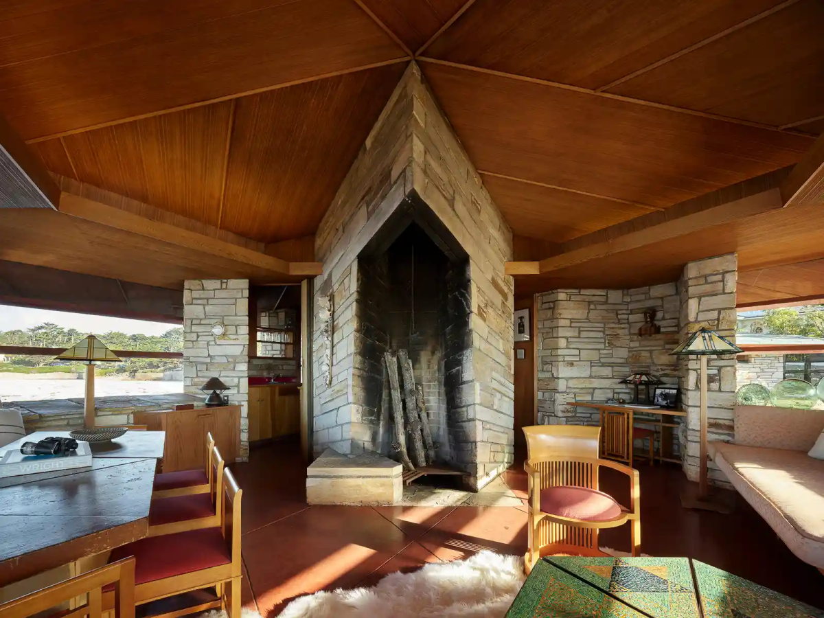 The fireplace in the living room. There are tables and chairs.