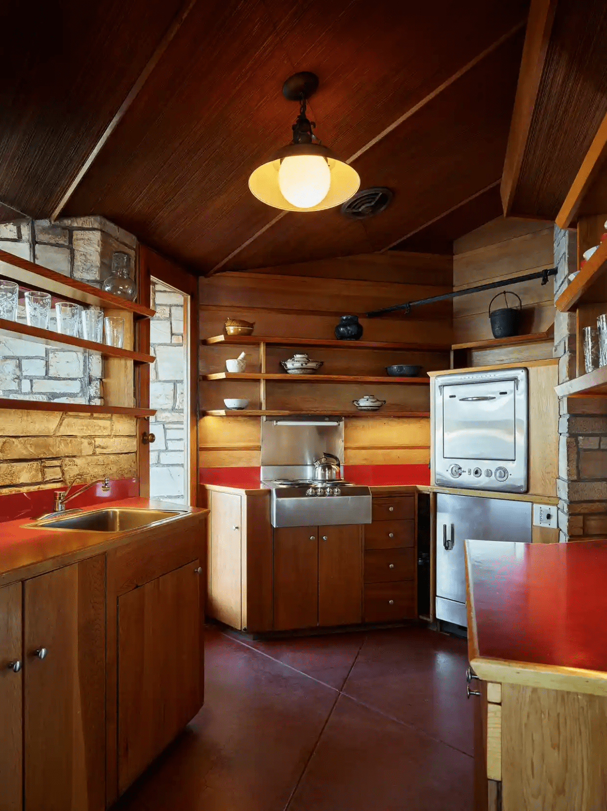 The small kitchen. There are basic silver appliances and a door to the outside.