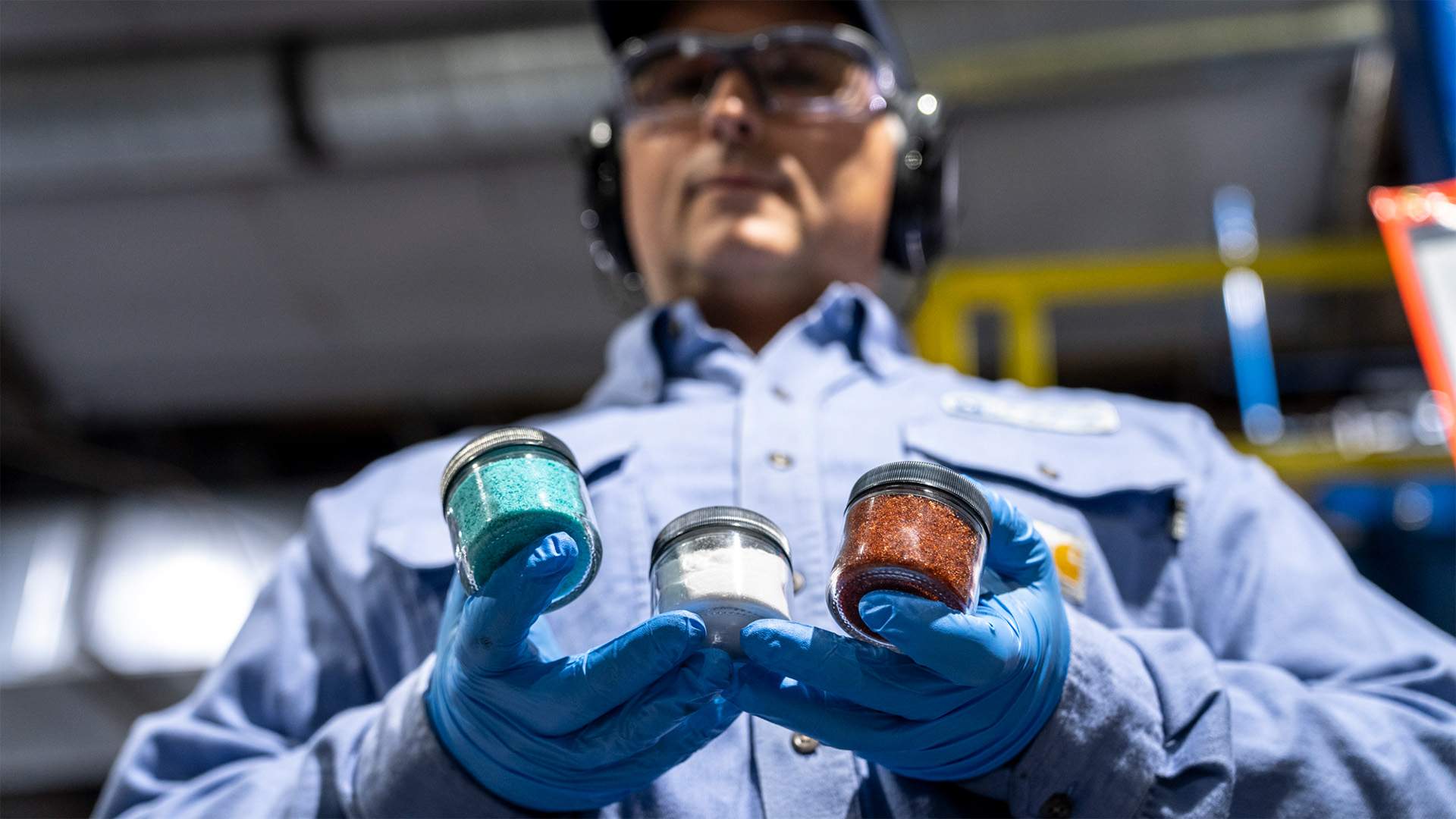 Li-Cycle plant manager, Daniel Demers, holds nickel sulfate, lithium carbonate, and cobalt sulfate.