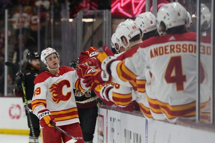 Calgary Flames left wing Jakob Pelletier (49) is congratulated for his goal against the Arizona Coyotes during the third period during an NHL hockey game Wednesday, Feb. 22, 2023, in Tempe, Ariz. The Flames won 6-3.