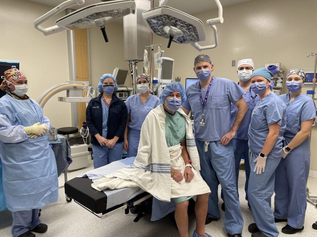 Staff and patient prior to prior to the first Insignia femoral stem implant in hip arthroplasty surgery being completed in Ontario at Ross Memorial Hospital on Feb. 15, 2023. Shown are, from left, Christine Ham, RPN; Susan Dallas-Wood, registered nurse first assist; Katie Oliver, RN; Arthur Goard, patient; Dr. Sebastian Heaven, orthopedic surgeon; Dr. Mohammed Hussein, anesthesiologist; Michelle McCombe, RN; and Kara Harman, RN.