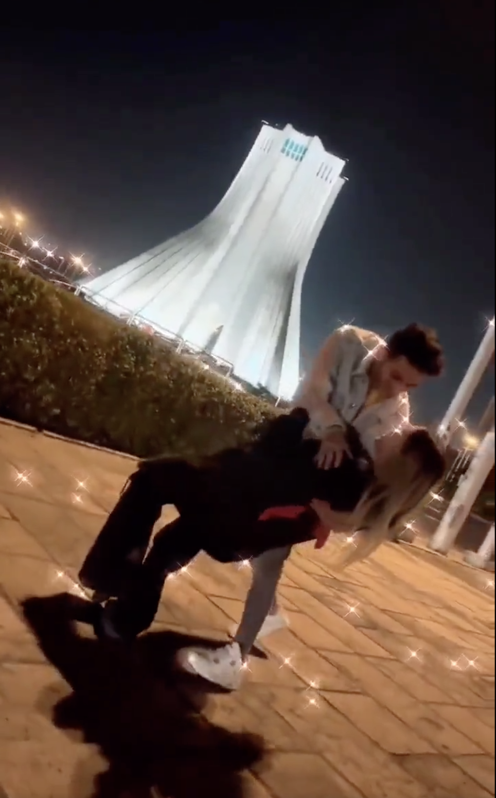 Screenshot of a viral video showing a young couple dancing in front of Iran's Azidi Tower.