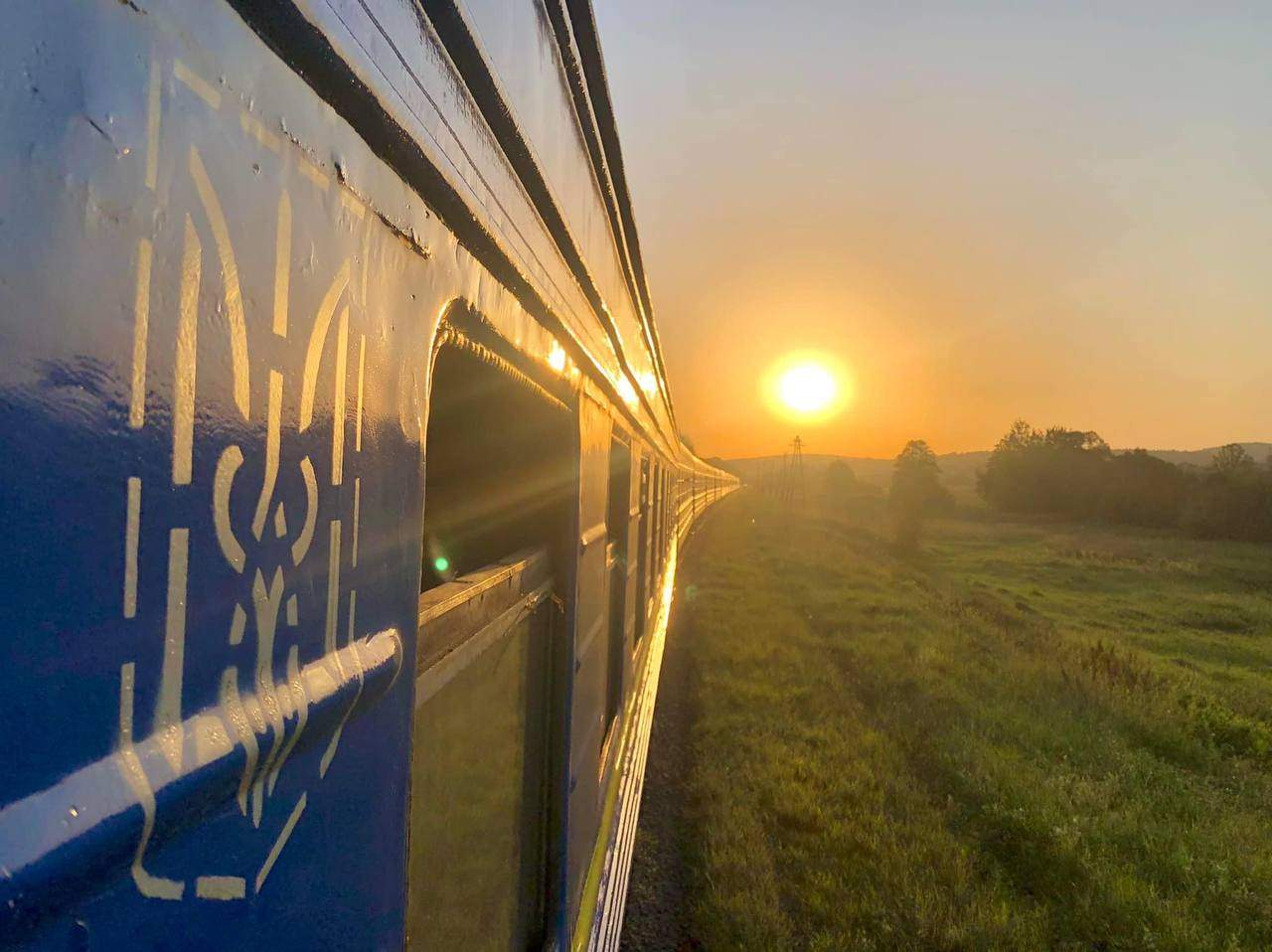 Ukrainian Railways train on the move at sunset.