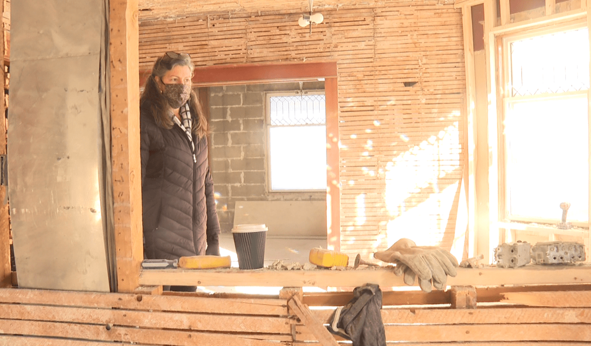 A woman stands in a home in the midst of renovation