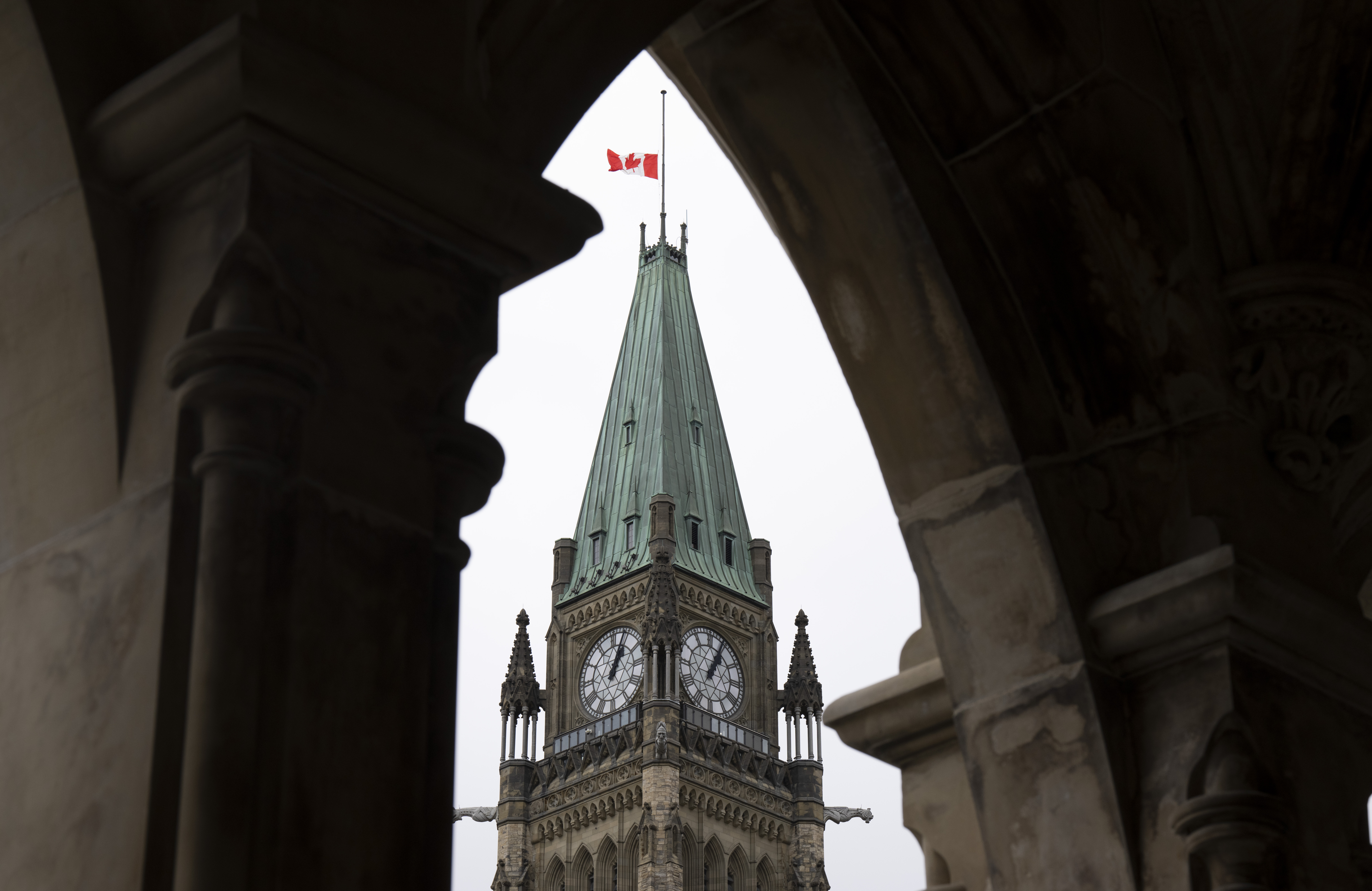 The Peace Tower on Parliament Hill is seen between an arch.