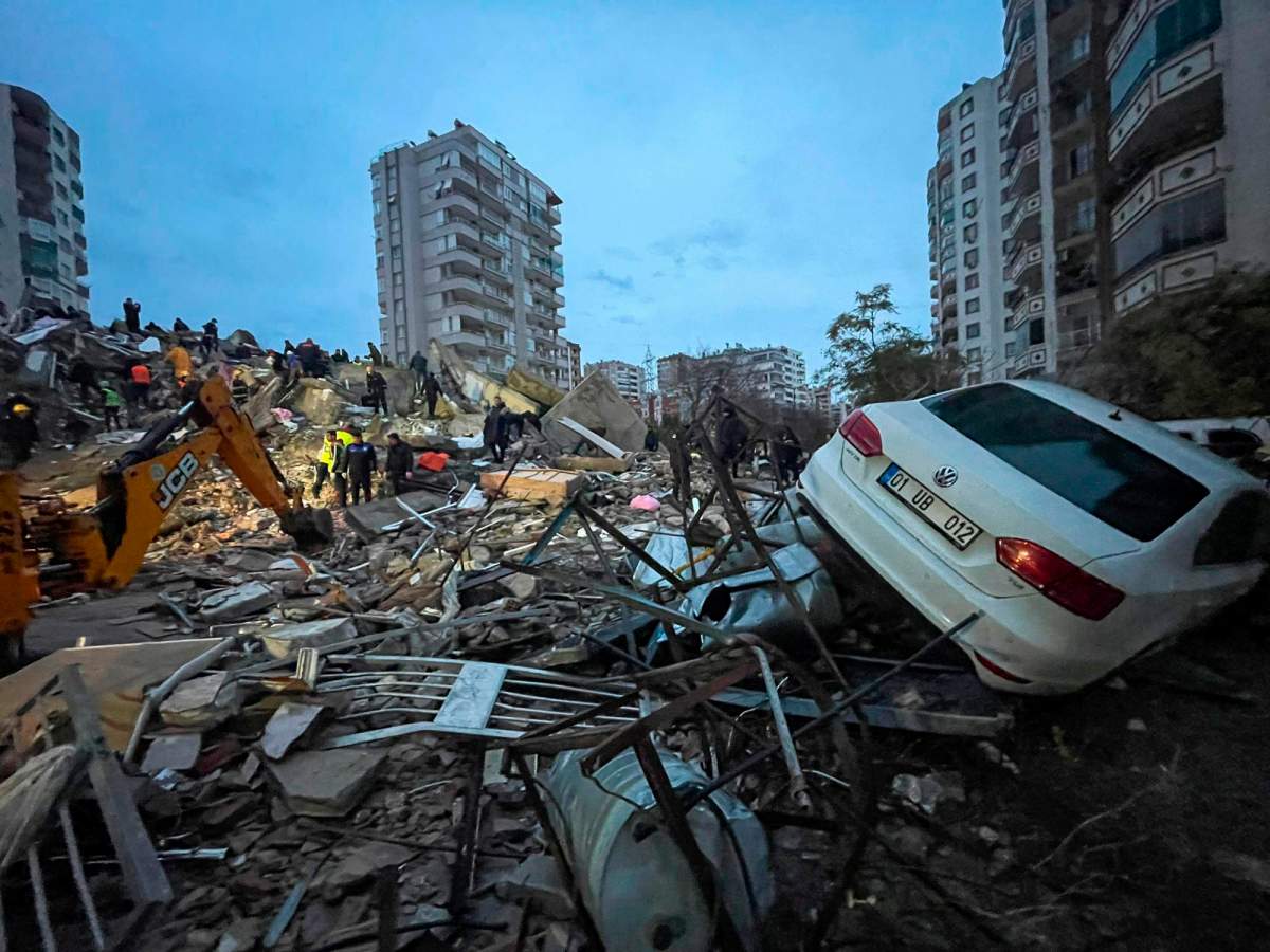 Emergency teams search for people in a destroyed building in Adana, Turkey,