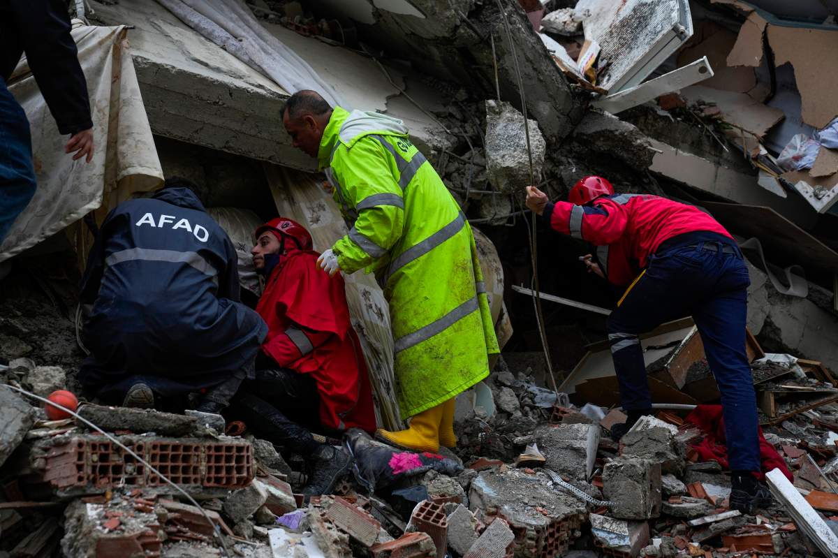 Emergency teams search for people through the rubble of a destroyed building in Turkey.
