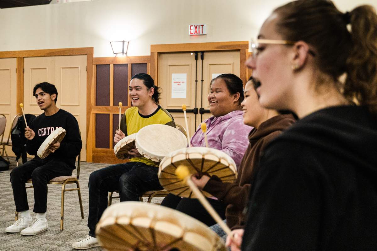 People sit in a circle with drums