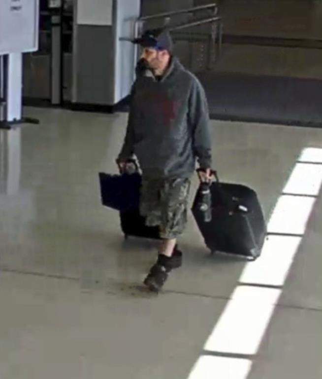 Marc Muffley holding two suitcases.