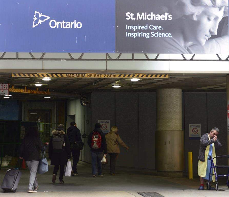 Ontario Provincial Police say two people have been charged after an investigation into a $300 million procurement project at Toronto's St. Michael's Hospital. People make their way pass construction at St. Michael's Hospital Queen street entrance in Toronto on Thursday Nov. 23, 2017.