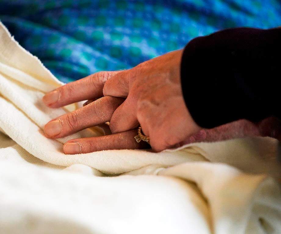 A patient has his hand held at a hospital, in Minneapolis, Monday, May 3, 2021.
