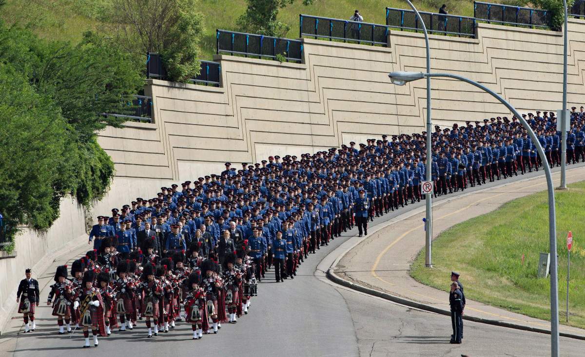 Police march during the funeral procession for slain police officer Const. Daniel Woodall, in Edmonton Alta, on Wednesday June 17, 2015.