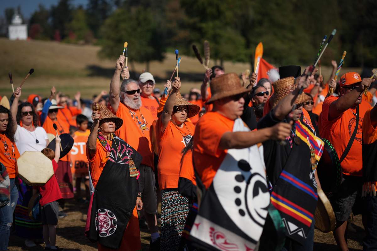 A group of people wearing orange shirts walk together.