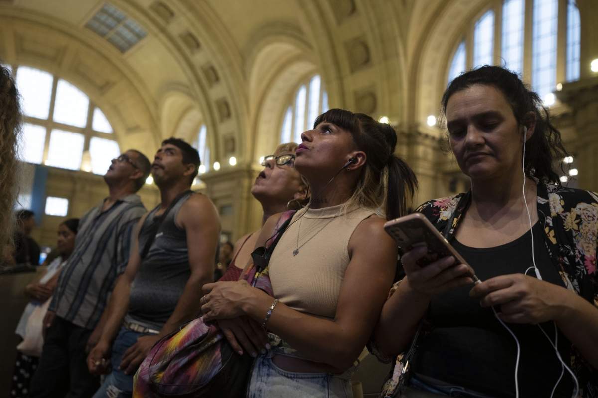 People wait for the train service to be restored following a major stoppage due to a power blackout, at Constitucion station in Buenos Aires, Argentina, Wednesday, March 1, 2023. Buenos Aires and several provinces in central Argentina were affected by a massive power blackout caused by a fire that knocked out three high-voltage lines, right in the middle of the worst heat wave in decades. (AP Photo/Victor R. Caivano).
